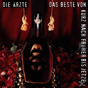 Albumcover mit Puppen in einem Sarg, mit Kreuz und deutschem Text. Roter Hintergrund.