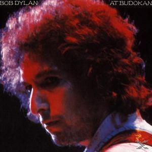 Bob Dylan Albumcover. Porträt von Bob Dylan mit roter Beleuchtung. Text 'At Budokan'.