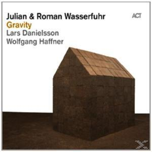 Albumcover: Braune Hausform auf dem Boden. Text: 'Julian & Roman Wasserfuhr', 'Gravity'.
