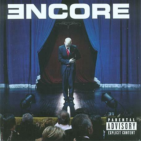 Eminem Encore CD-borítója. Eminem egy színpadon, reflektorral és kék függönnyel.