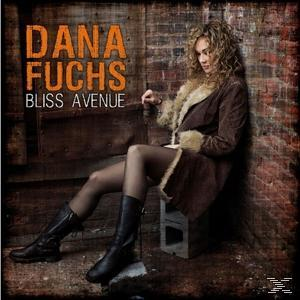Dana Fuchs sitzt an einer Backsteinmauer, auf einem Betonblock, mit Albumtitel in Orange.