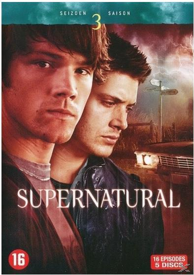 Couverture du DVD Supernatural. Deux hommes regardant la caméra. Fond sombre avec un panneau routier et une voiture.