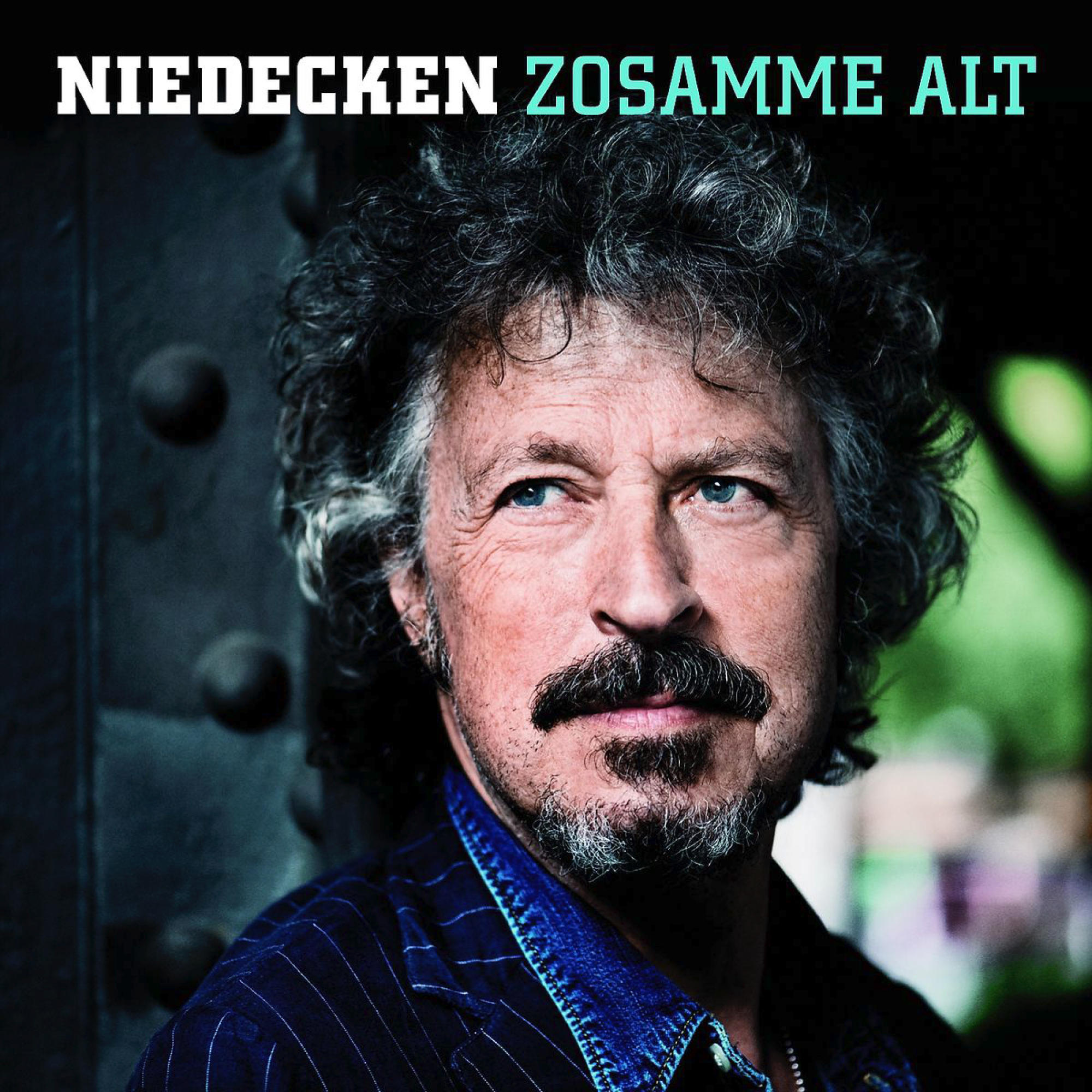 Porträt eines Mannes mit dunkelblauem Hemd und Text 'Niedecken Zosamme Alt'.
