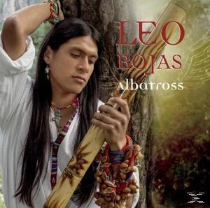 Ein Mann mit langen Haaren hält eine Flöte. Text steht über seinem Kopf: LEO ROJAS, albatross.