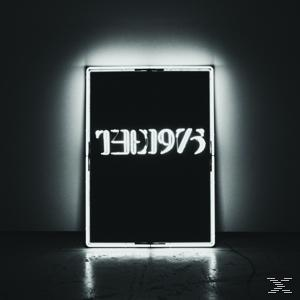 Ein Leuchtschild mit "THE 1975" in weißer Schrift auf schwarzem Hintergrund, mit weißem Rand.