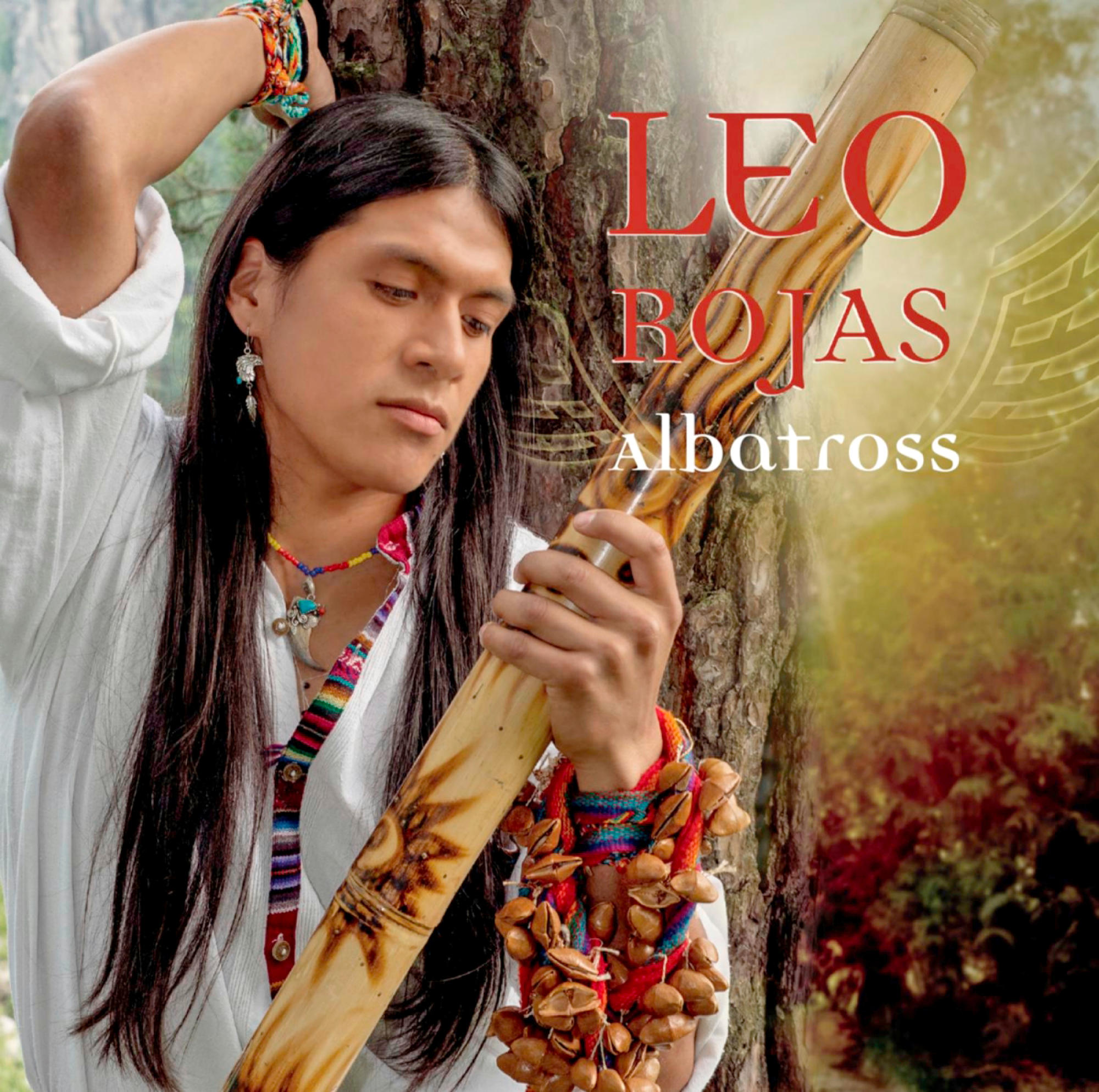 Albumcover von Leo Rojas, der ein Didgeridoo hält, neben einem Baum. Der Titel ist rot.
