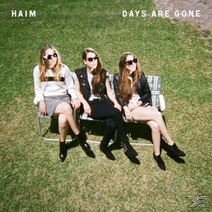 Albumcover mit drei Frauen mit Sonnenbrillen auf einer Bank im Gras.