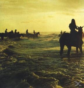 Bild von Menschen, die bei Sonnenuntergang durch Wasser reiten.