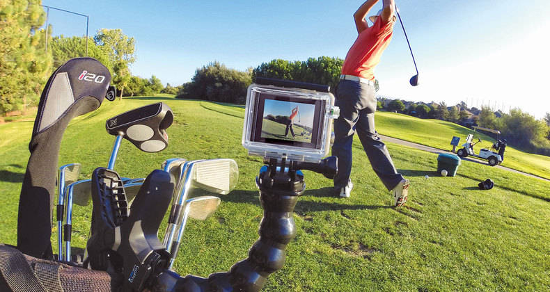 Golfer beim Schwingen, GoPro am Golfschläger, Golfplatz im Hintergrund.