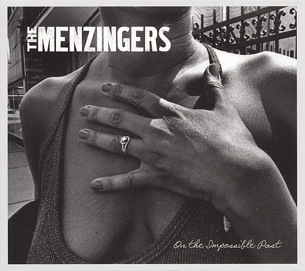 Albumcover in Schwarz-Weiß. Brust einer Frau und eine Hand mit Ring.
