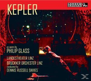 Opernplakat: 'Kepler', Mann im Scheinwerferlicht, Bühnenbild, roter Hintergrund.