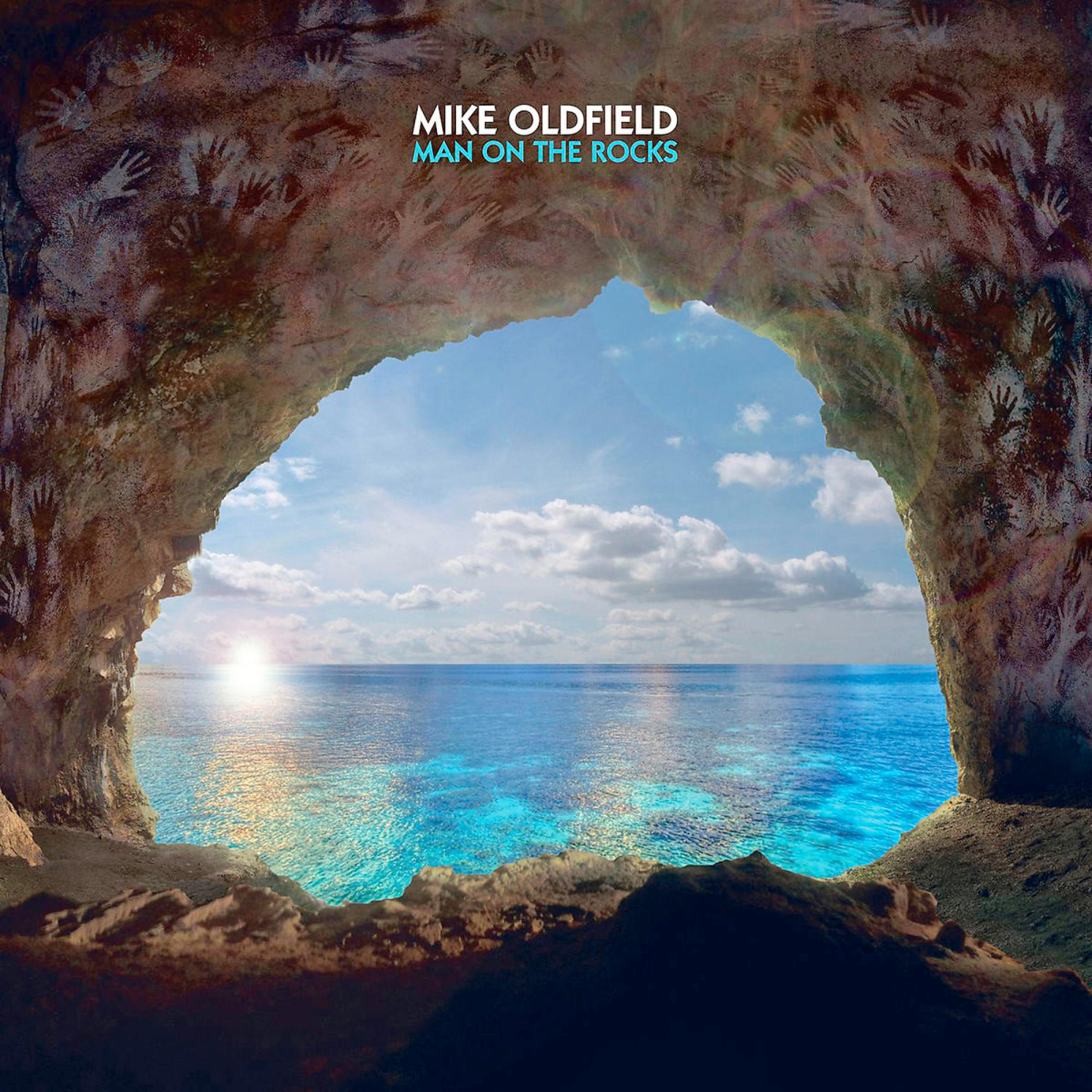 Höhlenöffnung mit Meerblick. Hände an der Höhlenwand. Blaues Meer, sonniger Himmel.