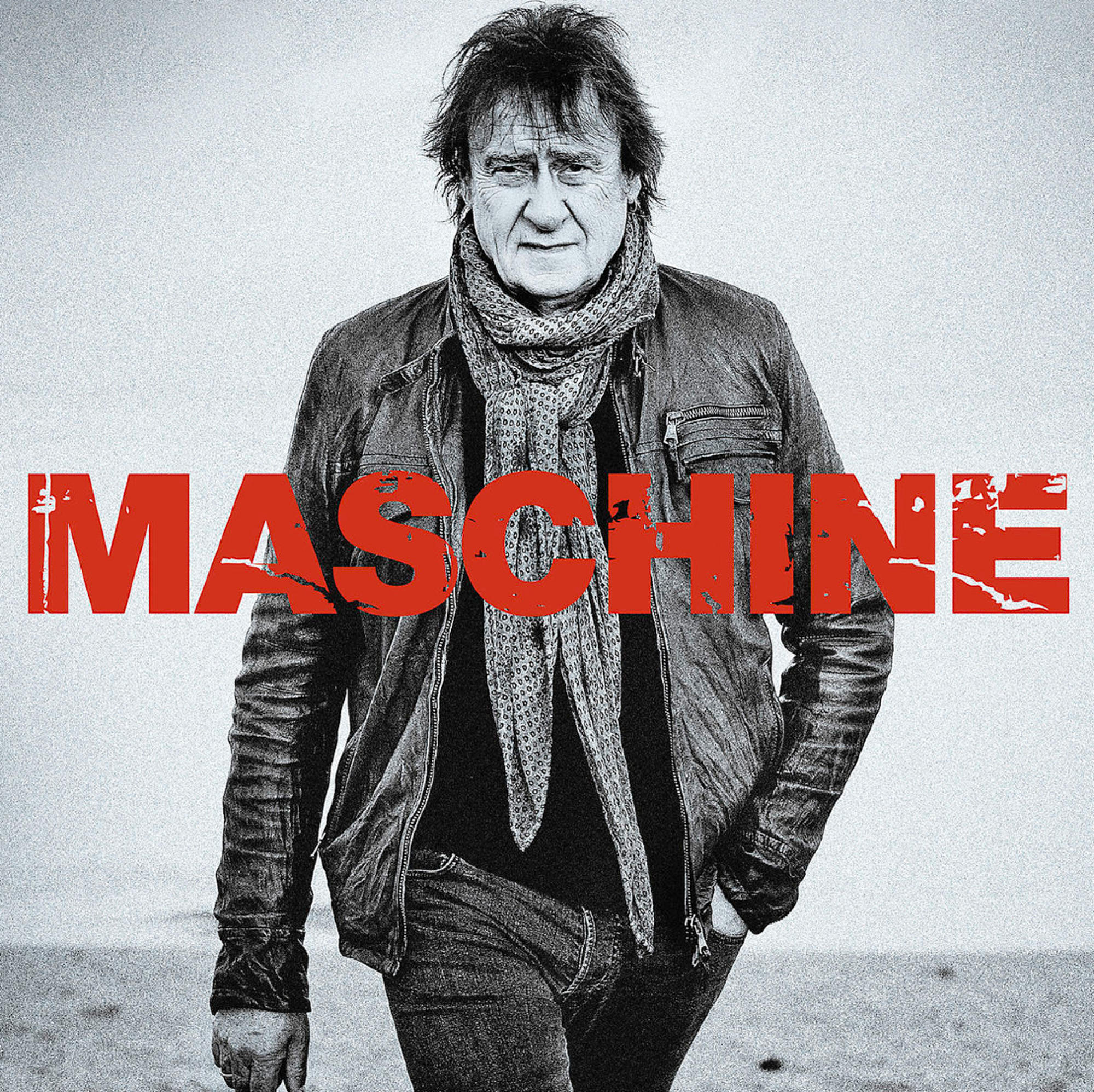 Mann in Lederjacke, Schal und Jeans mit MASCHINE-Text-Overlay.