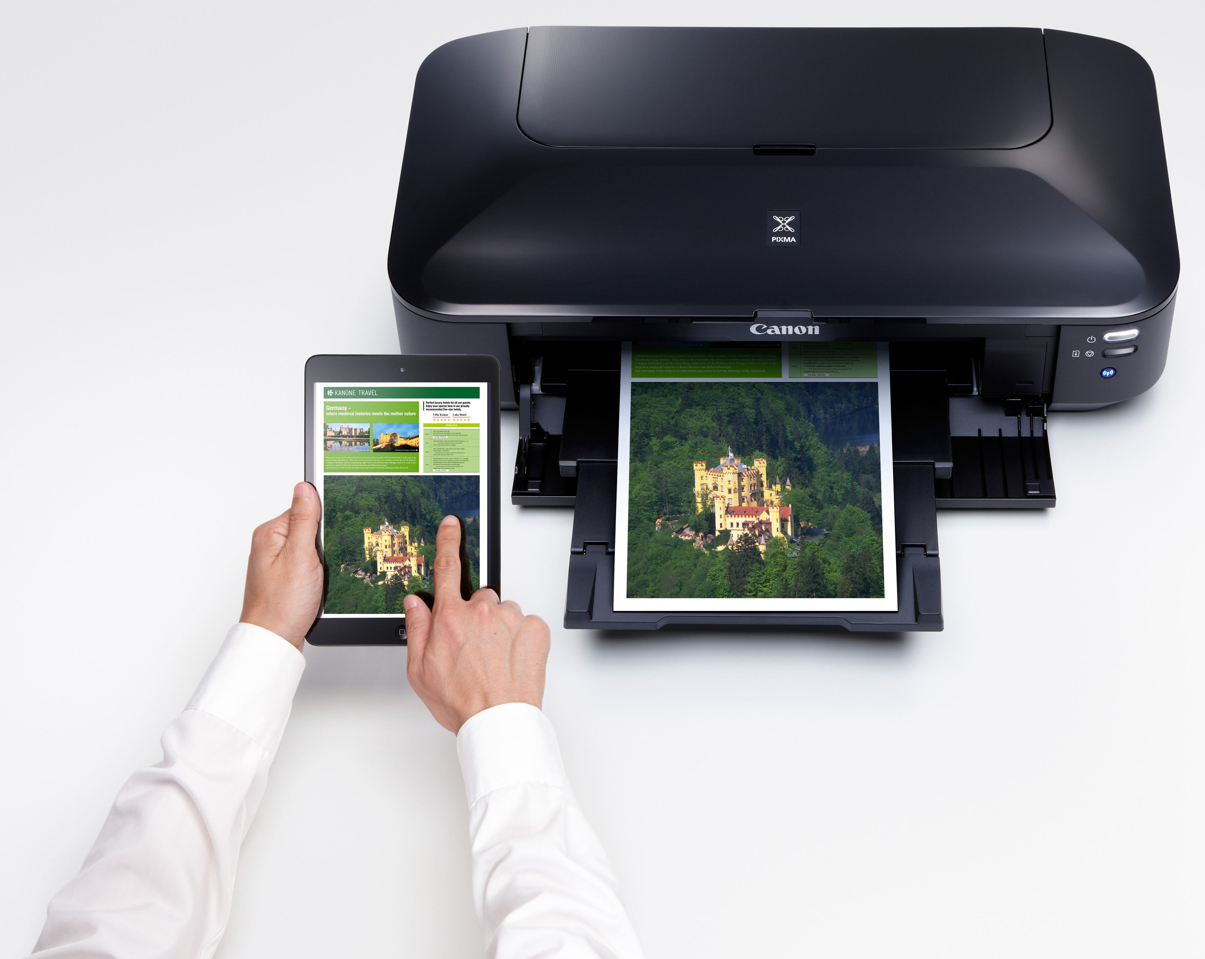 Canon printer printing an image from a tablet. A person holds the tablet. White background.