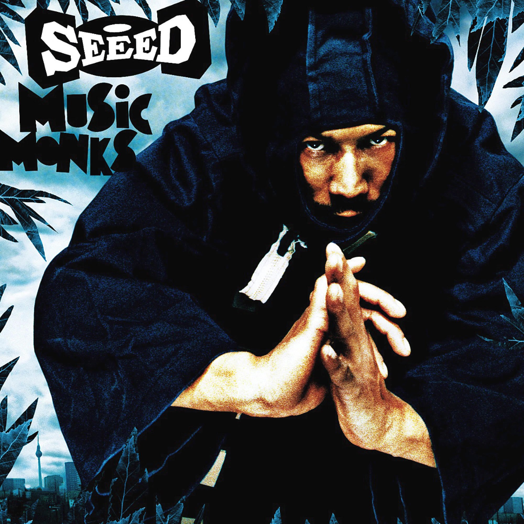 Albumcover von Seeed, ein Mann mit Kapuze schaut den Betrachter an, Hände zusammen.