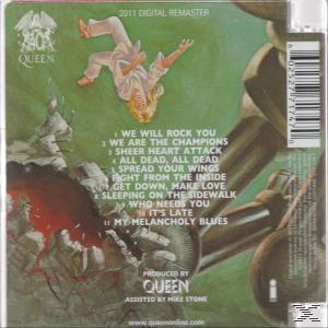 Queen-Albumcover mit einer schwebenden Figur. Die Titelliste des Albums ist sichtbar. Grüner Hintergrund.