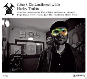 Ein Mann mit bunten Brillen steht in einem Pub. Der Hintergrund zeigt eine Bar und Schilder.