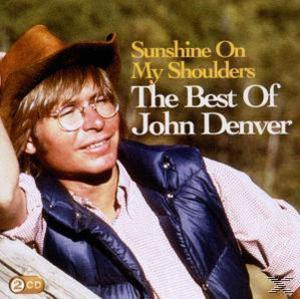 The Best Of John Denver Albumcover. John Denver mit Cowboyhut und Weste, lächelnd. Braun- und Blautöne werden verwendet.