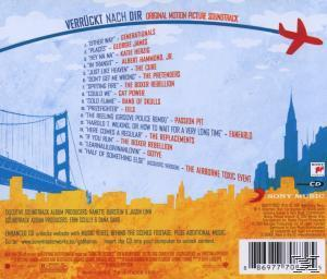 CD-Cover mit einer Brücke, Gebäuden und einem Flugzeug, mit Text und Titellisten.