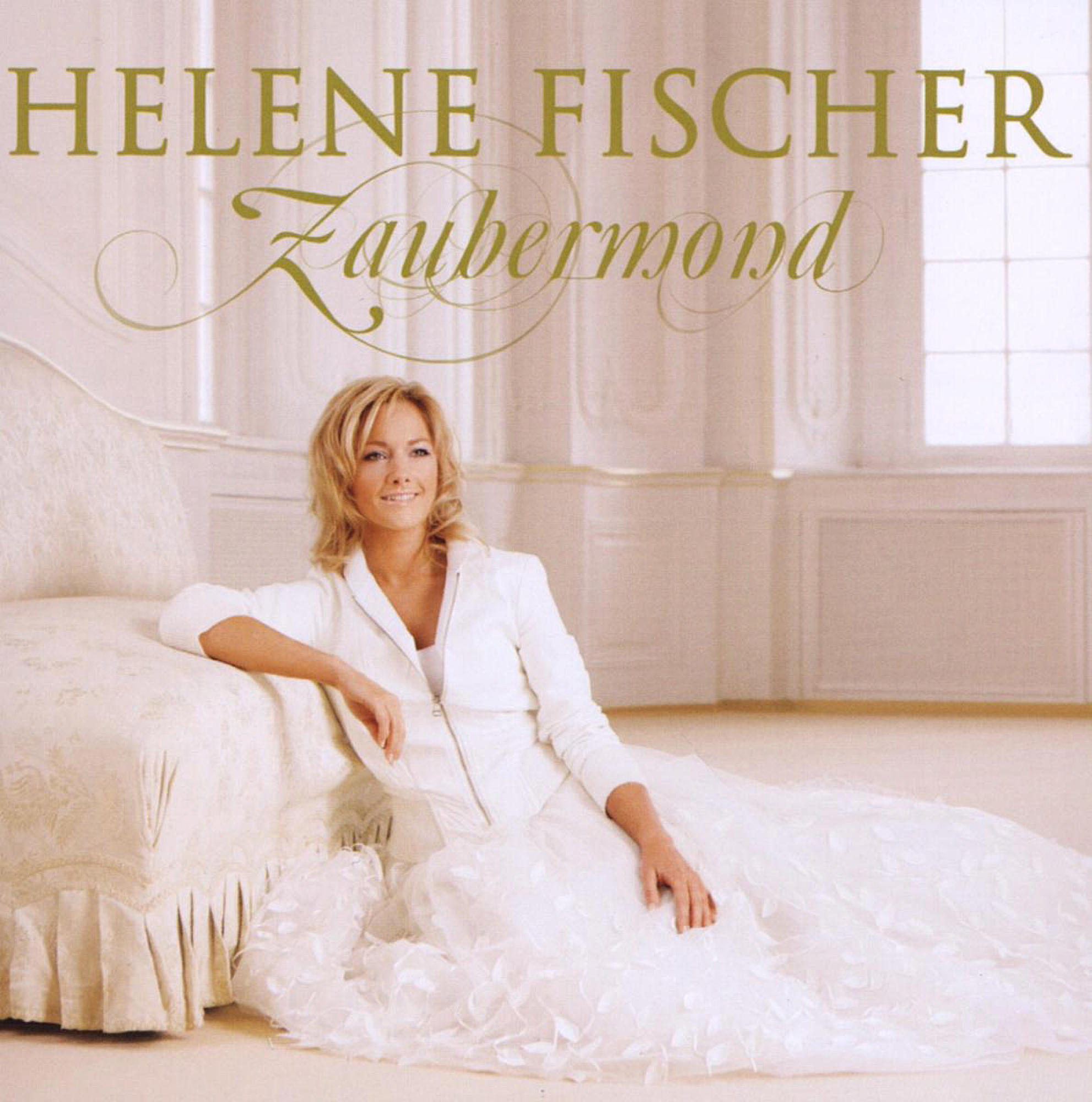 Helene Fischer auf einem Albumcover. Sie trägt ein weißes Kleid, sitzt auf einer Couch in einem hellen Raum.