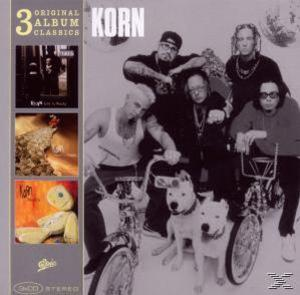 Albumcover. Korn-Bandmitglieder mit Fahrrädern. '3 Original Album Classics' und 'Korn'-Text.