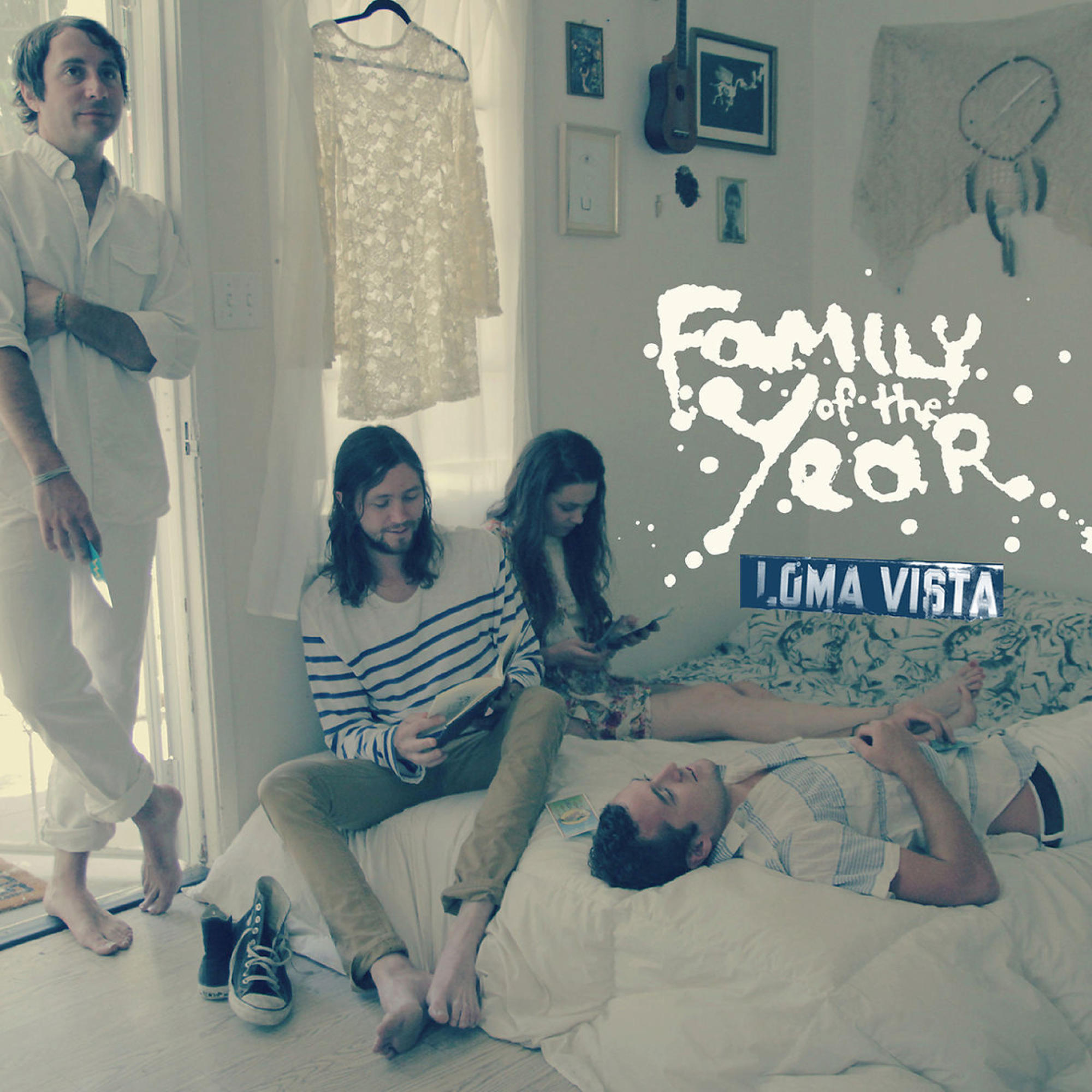 Band in einem Raum, Family of the Year Text, ein Bett mit Leuten und ein Fenster.