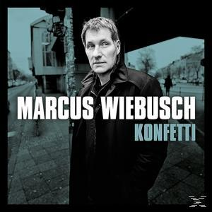 Albumcover mit einem Mann in Schwarz und dem Titel 'Konfetti' in Weiß, Stadt-Hintergrund.