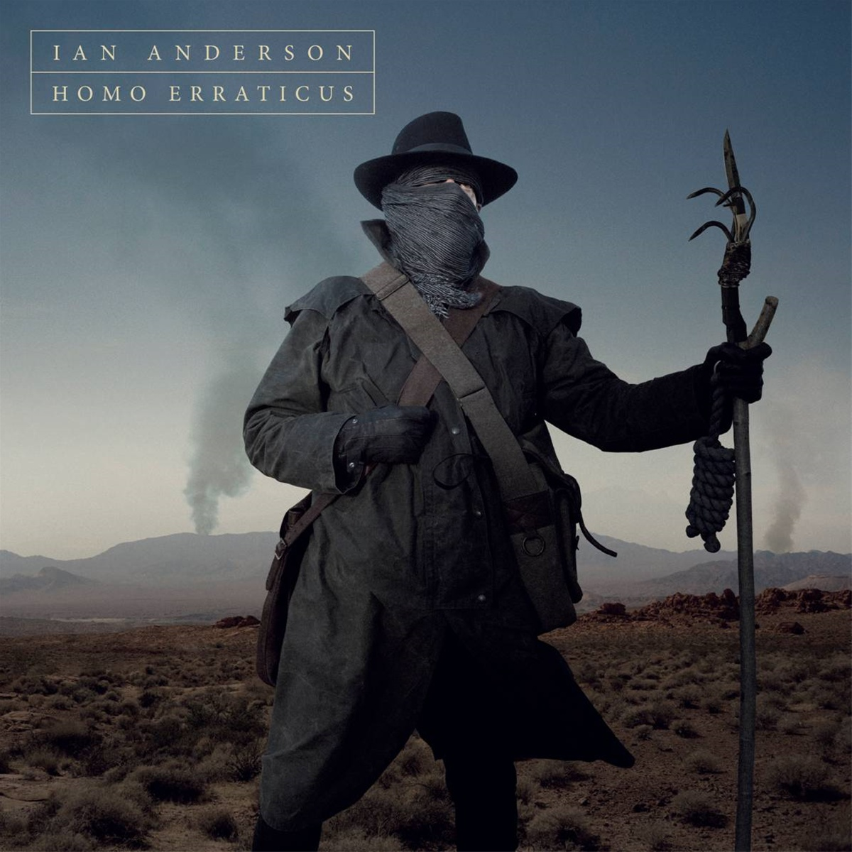 Albumcover mit einem Mann mit Hut und Schal, der einen Speer hält, in einer Wüstenlandschaft.