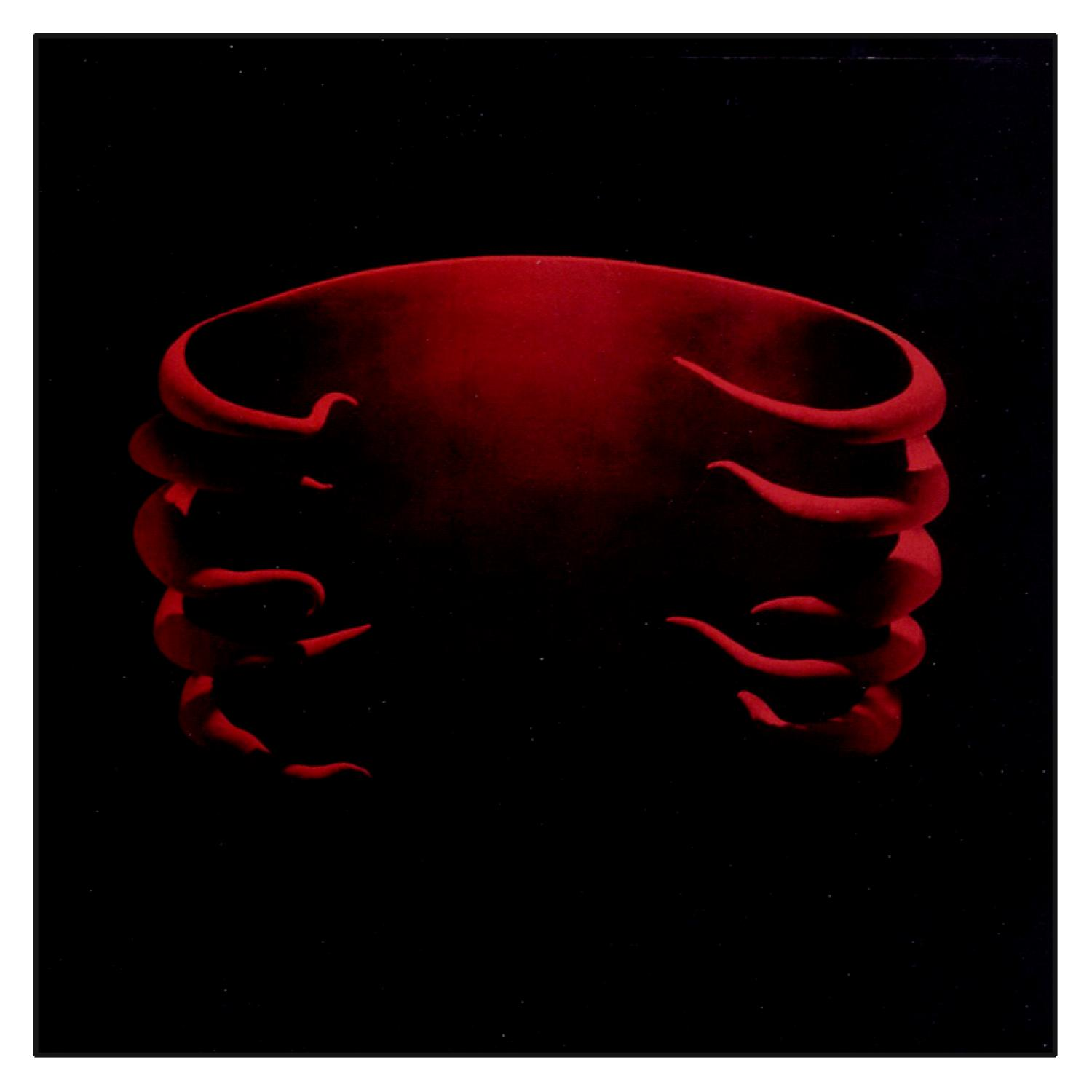 Albumcover mit roten abstrakten Formen auf schwarzem Hintergrund.