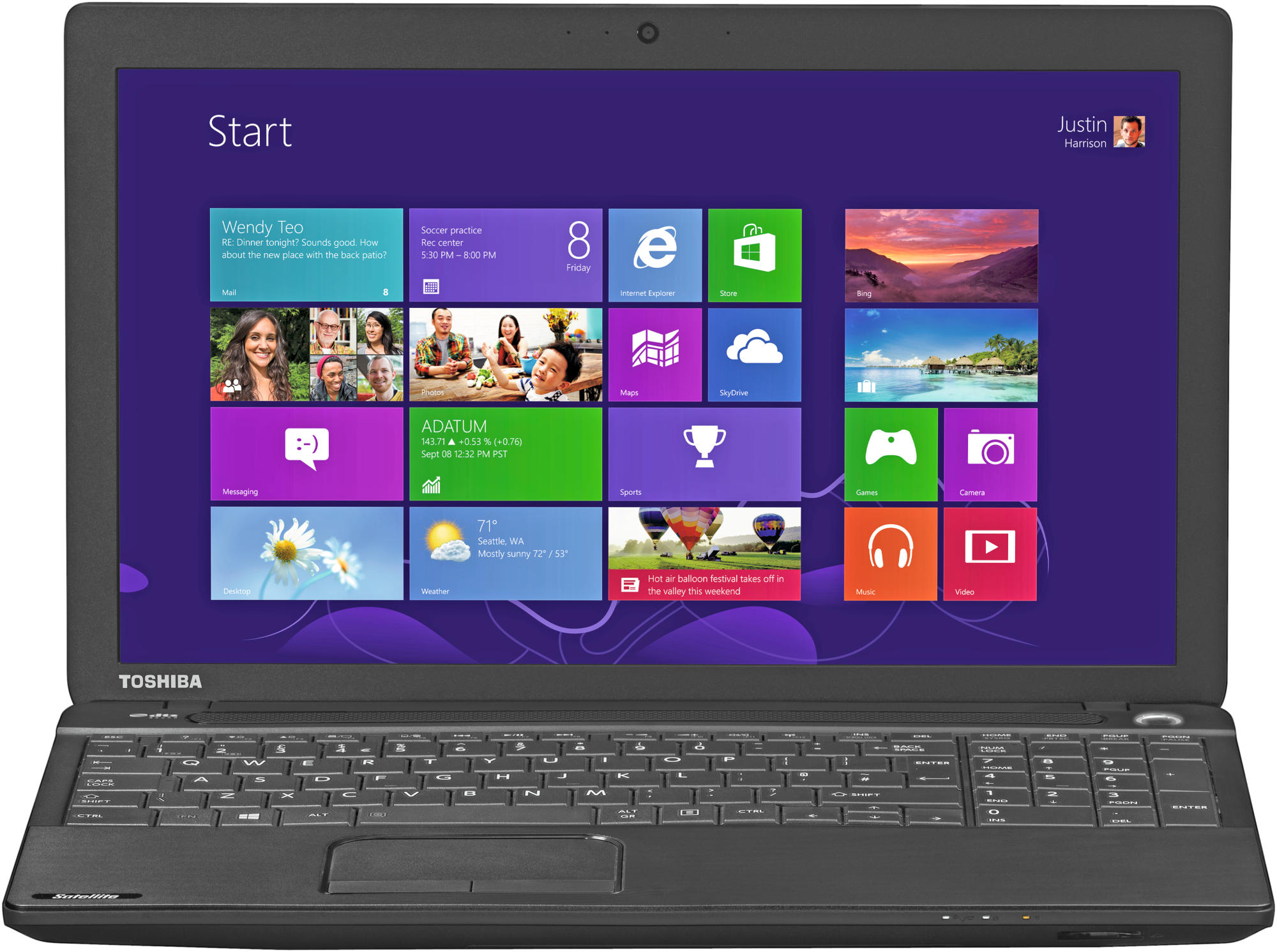 Un portátil Toshiba negro con la pantalla de inicio de Windows 8. Varios mosaicos de aplicaciones son visibles.