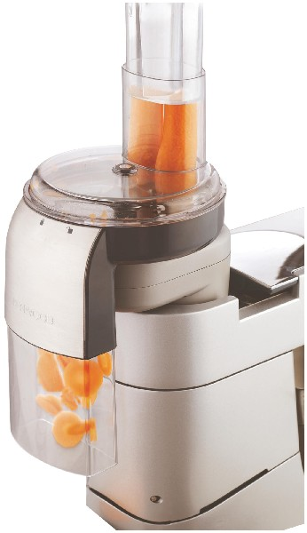 Küchenmaschine mit Karotten, die verarbeitet werden, und orangefarbenen Karottenstücken in einem durchsichtigen Behälter.