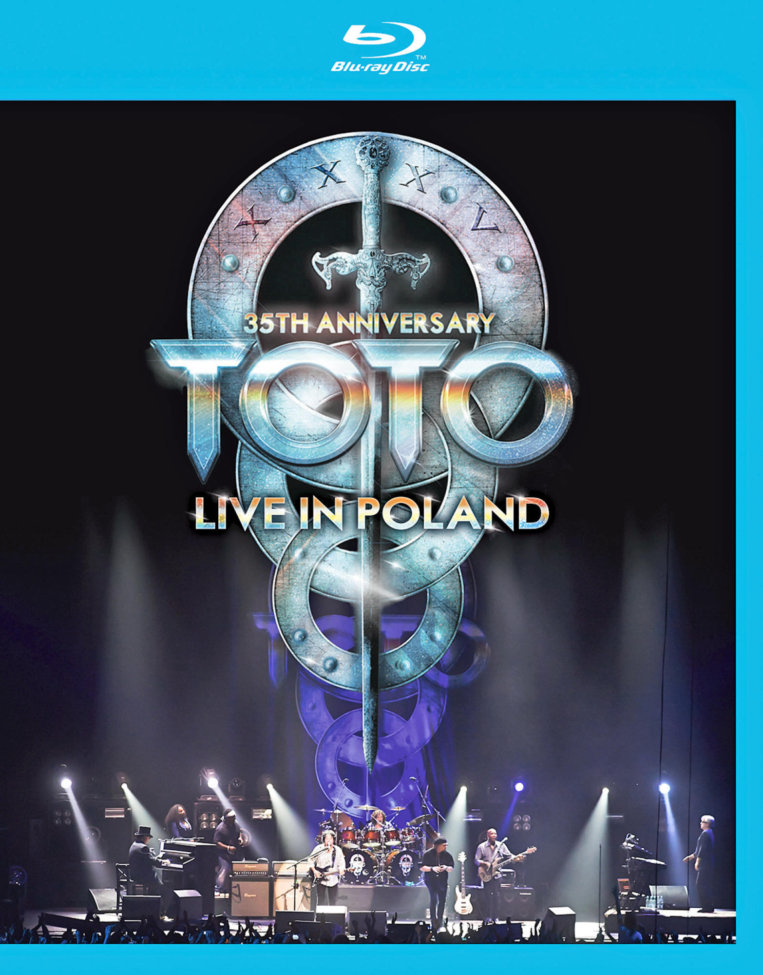 Blu-ray-Cover für 'Toto: Live in Poland' mit Bandmitgliedern auf der Bühne, mit Bühnenlicht und Logos.