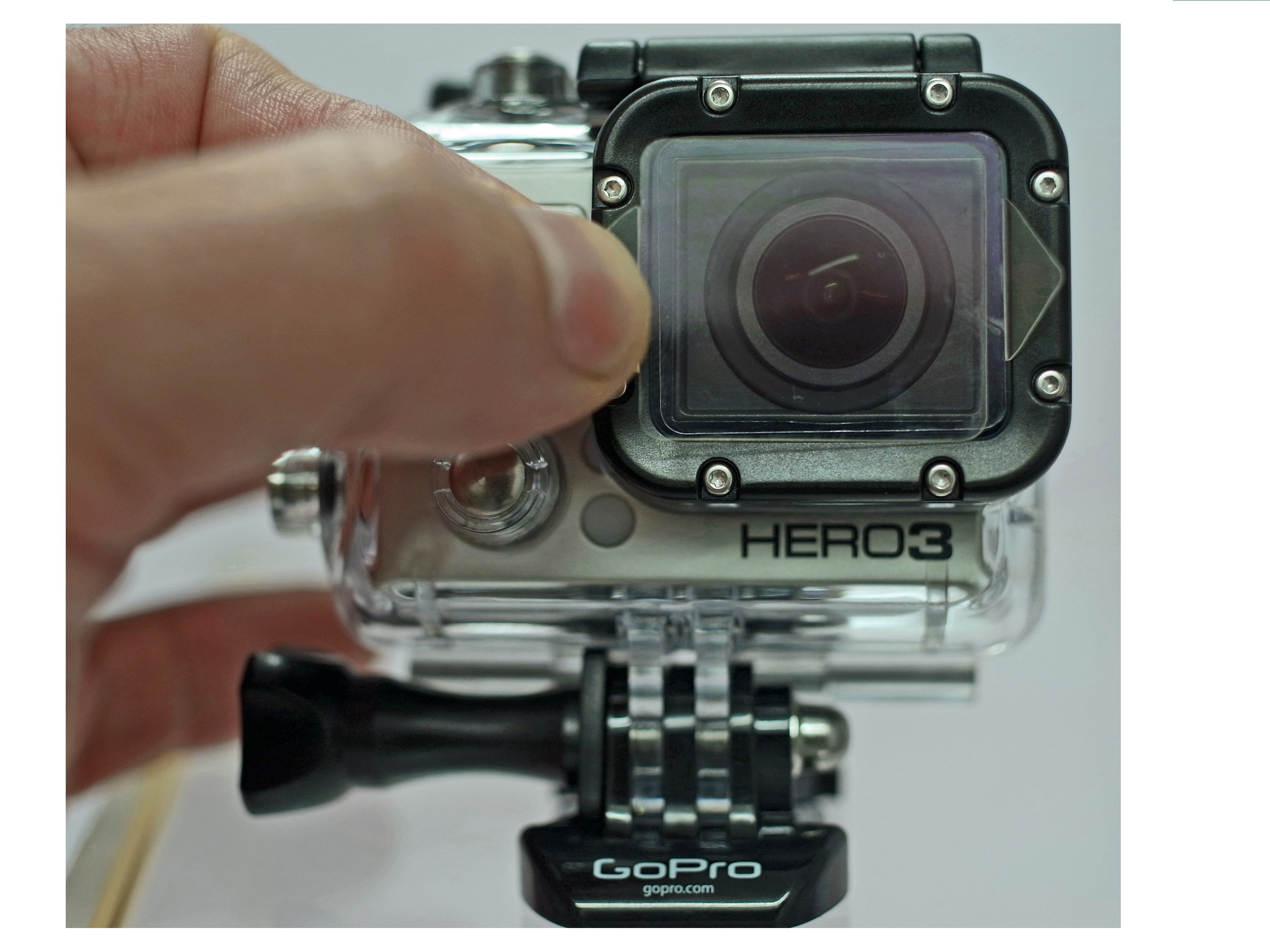Nahaufnahme einer GoPro Hero3-Kamera, eine Hand passt das Schutzgehäuse an.