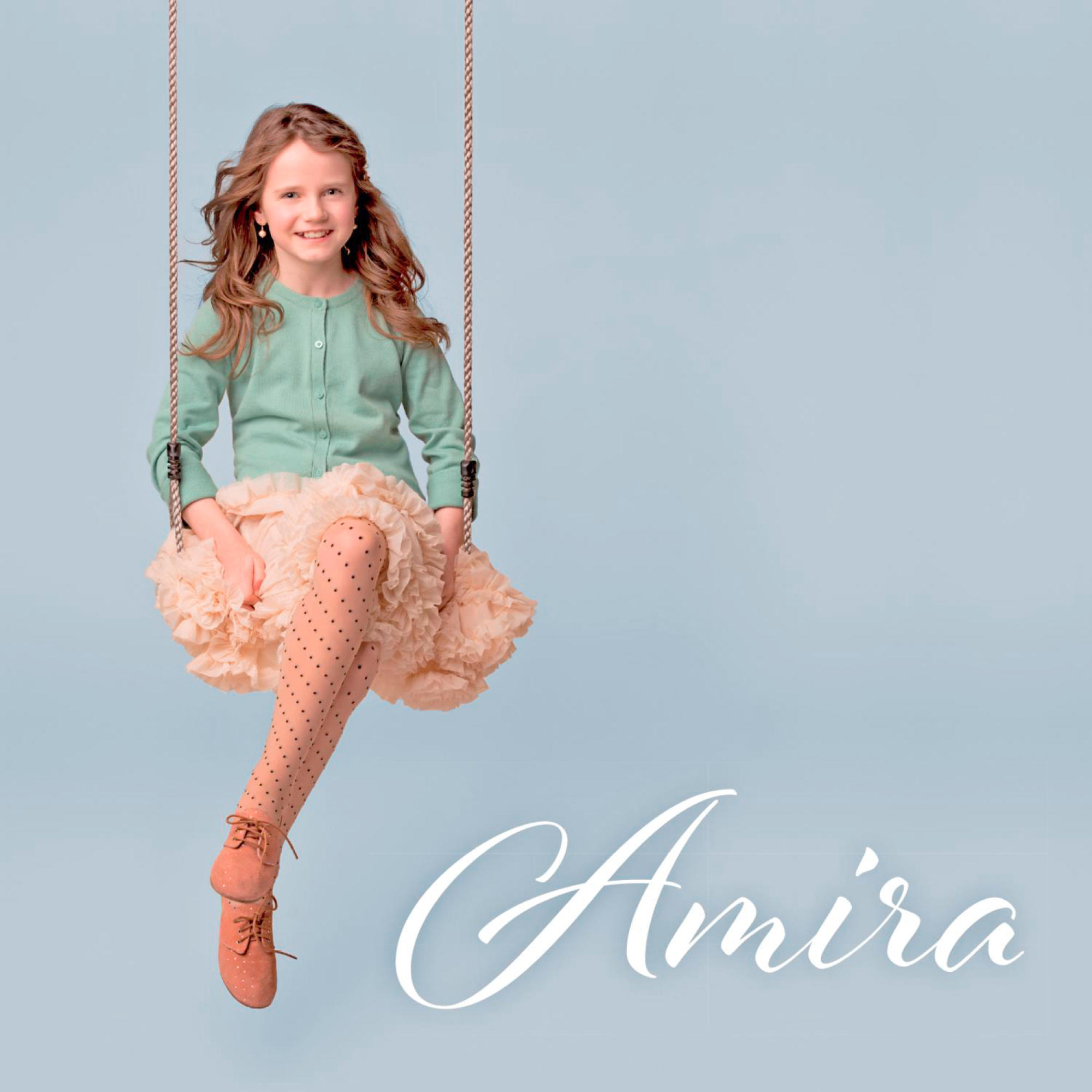 Ein junges Mädchen schaukelt auf einer Schaukel mit dem Namen Amira unten. Hellblauer Hintergrund.