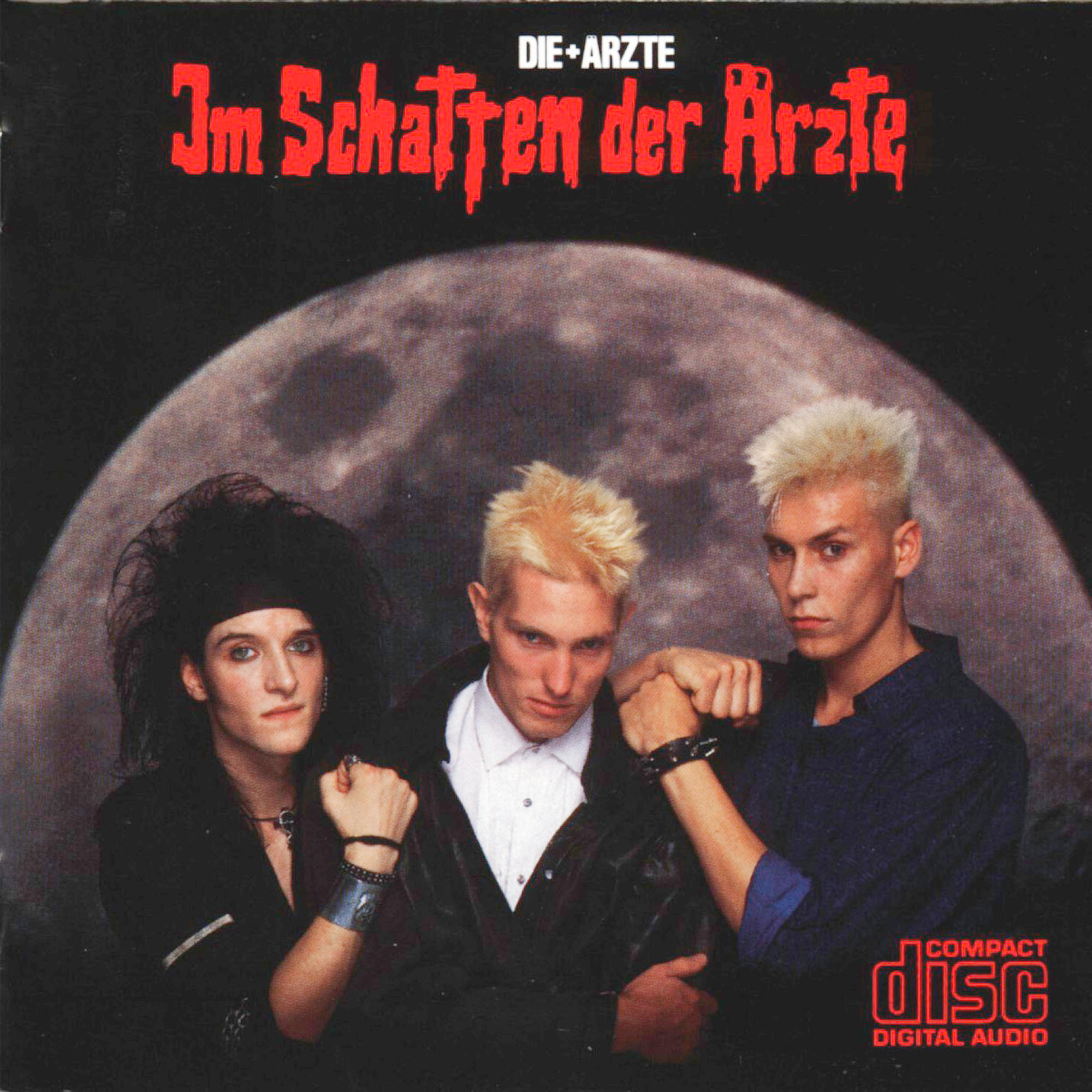 Albumcover mit drei Männern, Bandname und Albumtitel. Dunkler Hintergrund.
