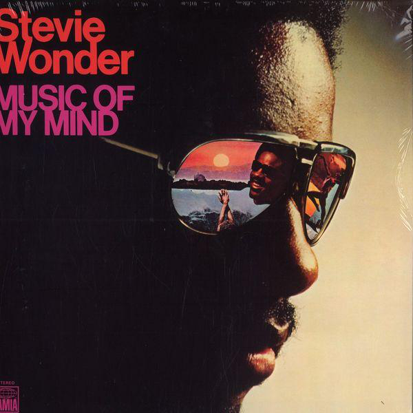 Album borító Stevie Wonder arcával napszemüvegben, mely naplementét és egy felemelt kezet tükröz.