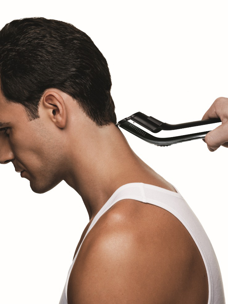 Der Nacken eines Mannes wird mit einem Haarschneider von einer anderen Person getrimmt.