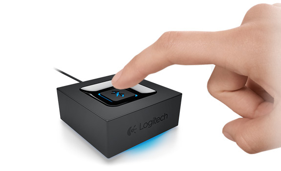 Ein Finger drückt auf eine Taste auf einem schwarzen und blauen Logitech-Gerät.