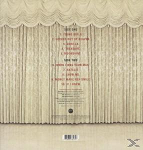 Rückseite einer Vinyl-Schallplatte. Songtitel aufgelistet. Beige Vorhang-Kulisse.