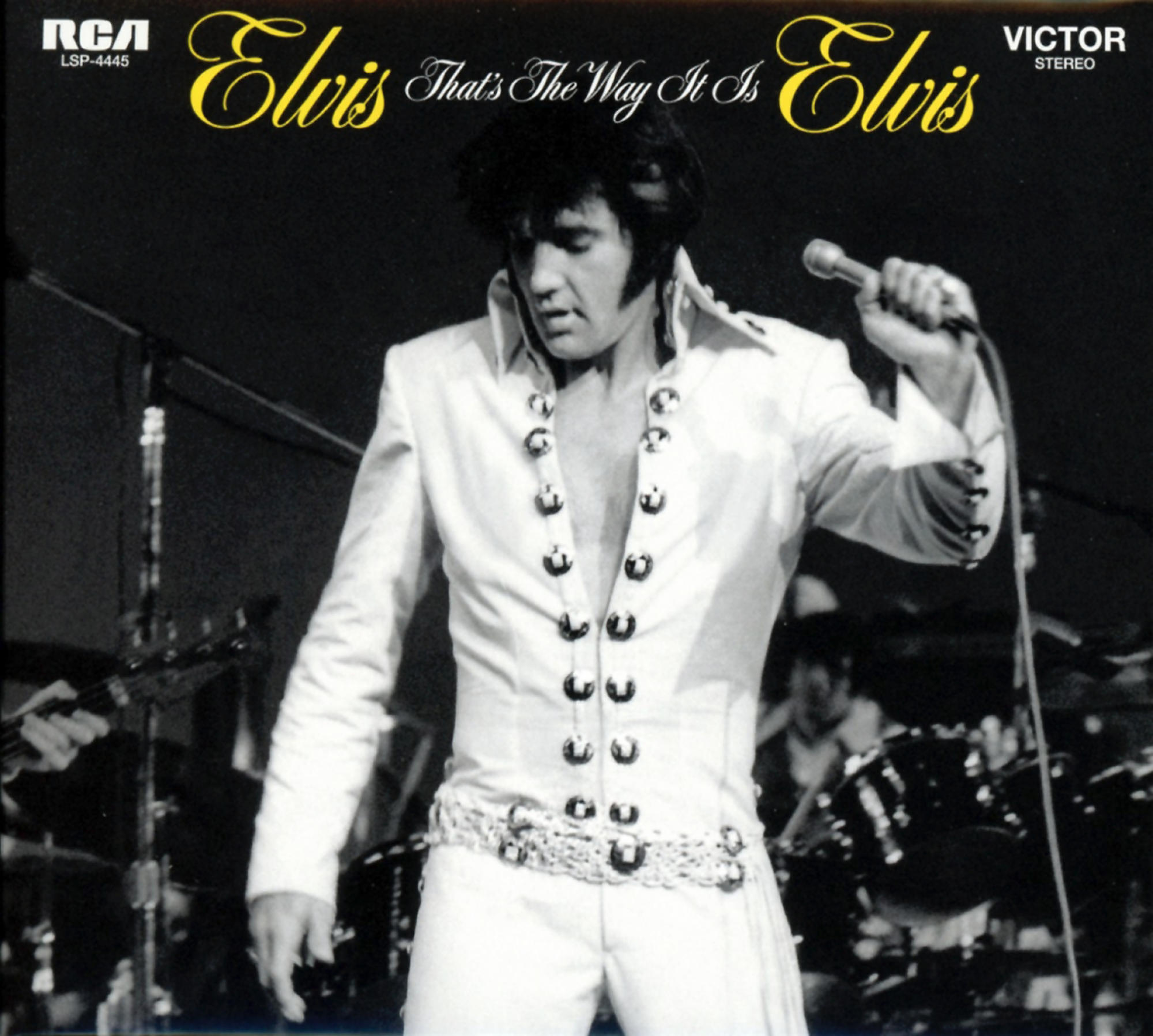 Elvis auf der Bühne in weißem Anzug mit Mikrofon. Albumcover 'That's The Way It Is'.