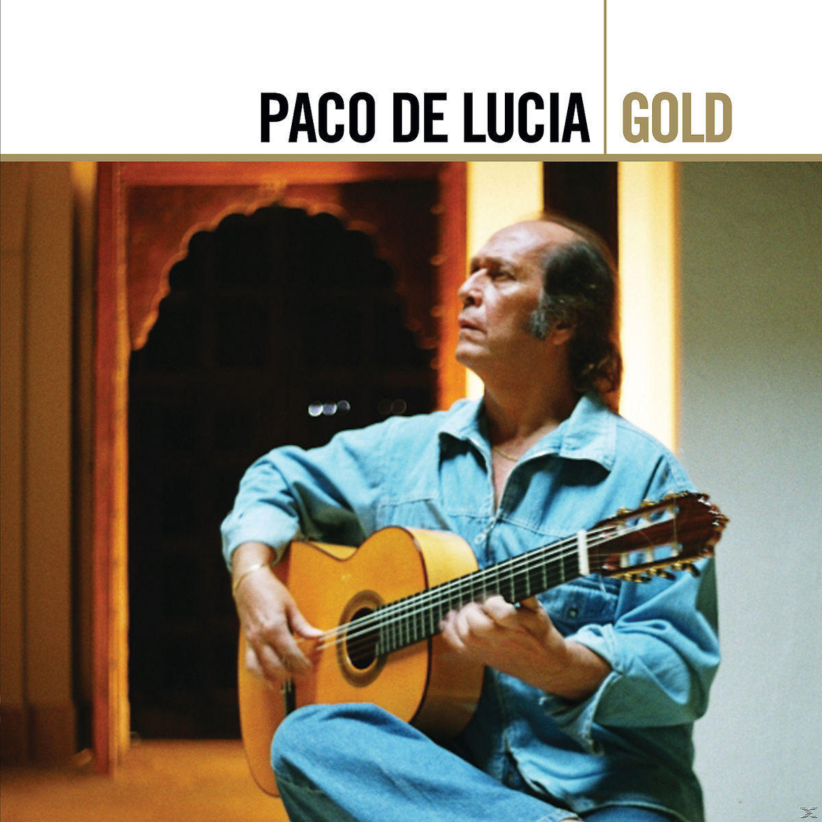 Mann spielt Gitarre; Paco de Lucía. Der Hintergrund zeigt einen Torbogen und eine Wand.