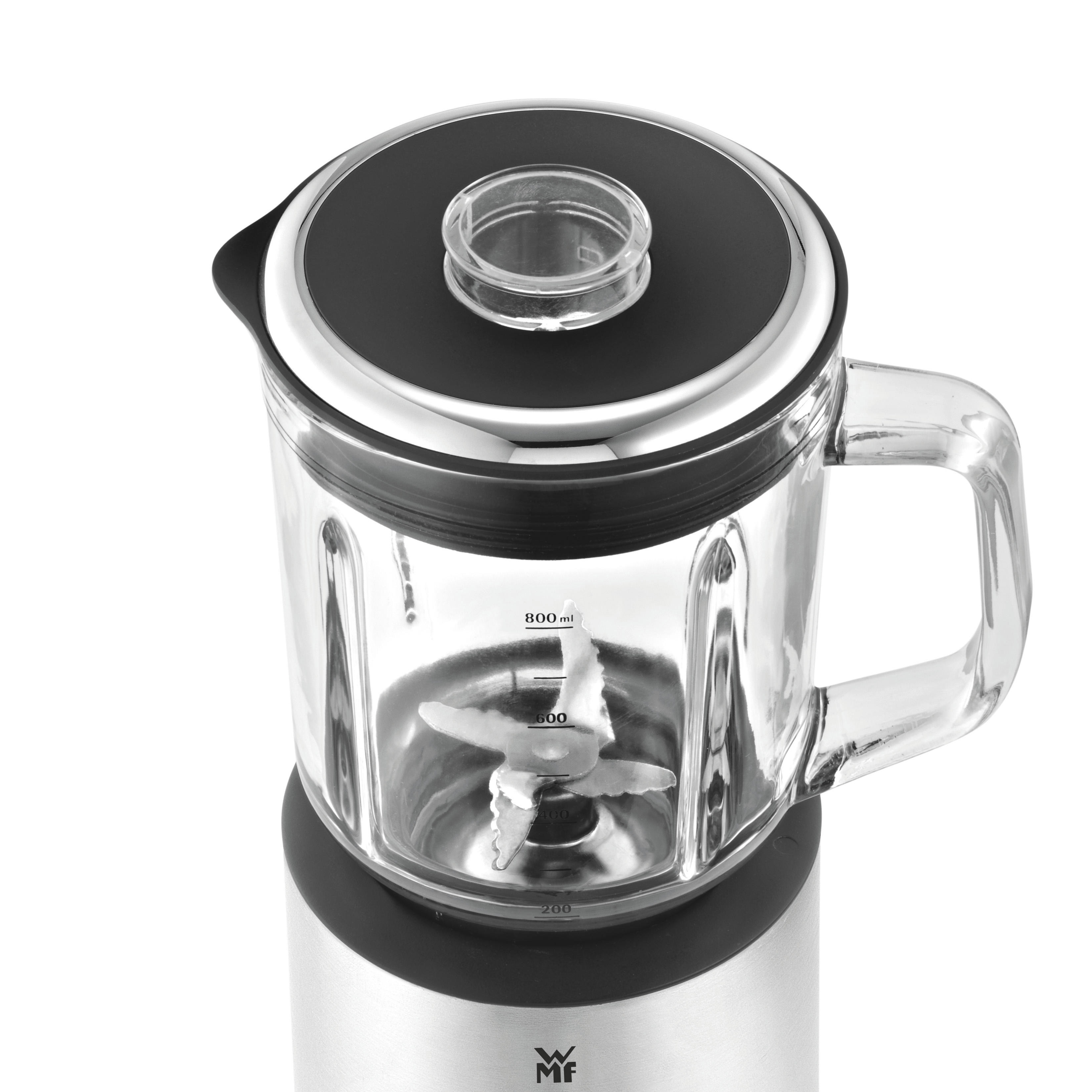 Close-up of a blender with a glass jar, metal blades, and black lid.