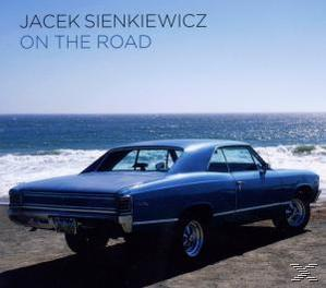 Albumcover 'On the Road' von Jacek Sienkiewicz. Blaues Auto am Strand, Ozean.