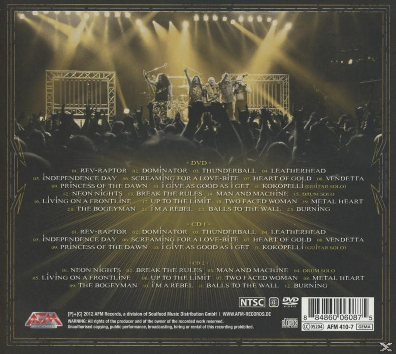 Konzertbild mit Band auf der Bühne, Publikum sichtbar, Bühnenbeleuchtung, Album-Trackliste.
