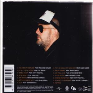 CD hátlap egy szakállas férfival, sapkával és napszemüveggel, valamint egy számlistával.