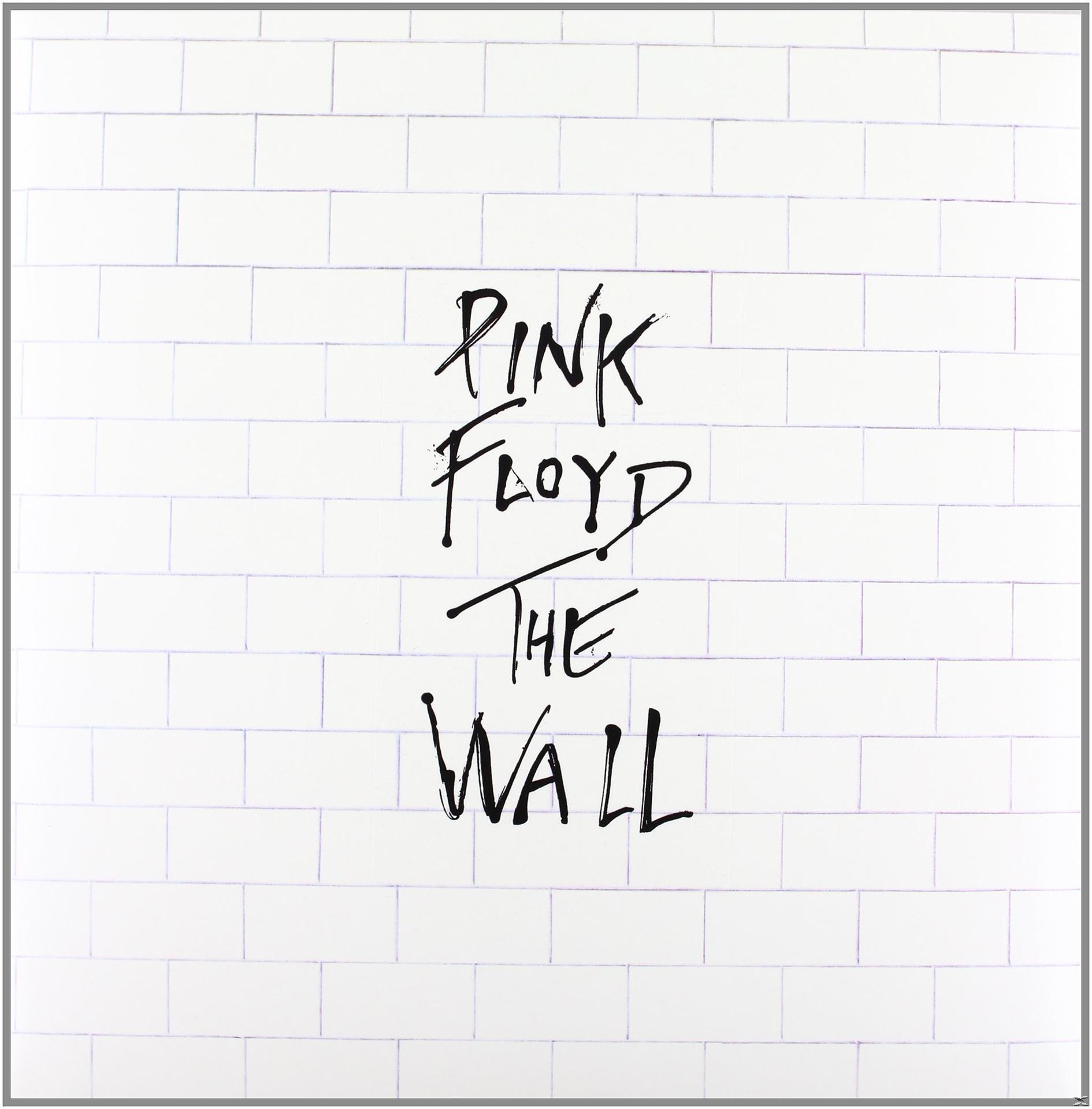 Weiße Backsteinmauer mit den Worten 'PINK FLOYD THE WALL' in schwarzer Kalligraphie geschrieben.