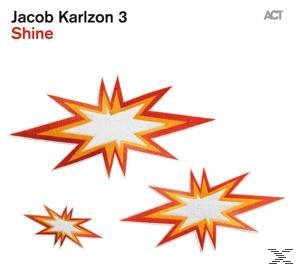 Albumcover für 'Shine' von Jacob Karlzon 3. Drei Sternausbrüche mit orange und weißen Farben.