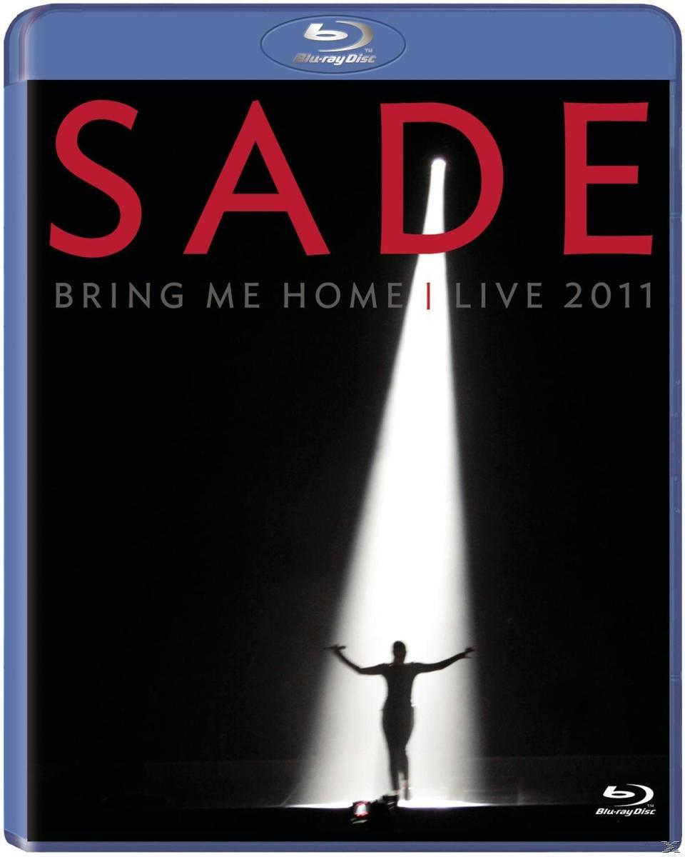 Sade-Albumcover mit einem Scheinwerfer auf einer Bühne und einer Frau.