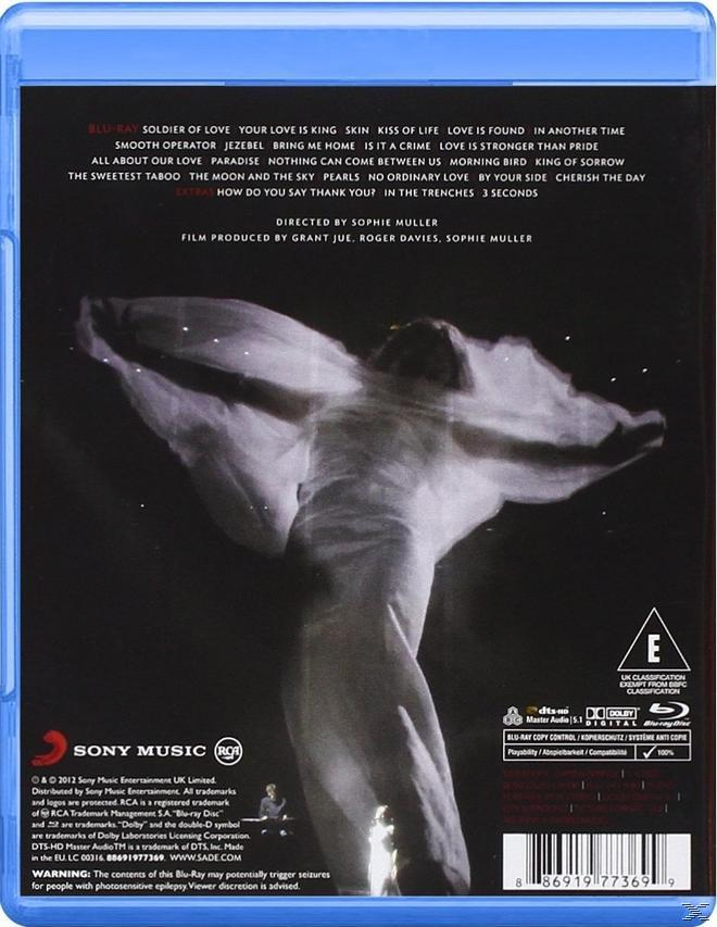 Blu-ray-Cover mit Liedtexten und einem ätherischen Bild einer Figur mit ausgestreckten Armen vor Sternenhimmel.