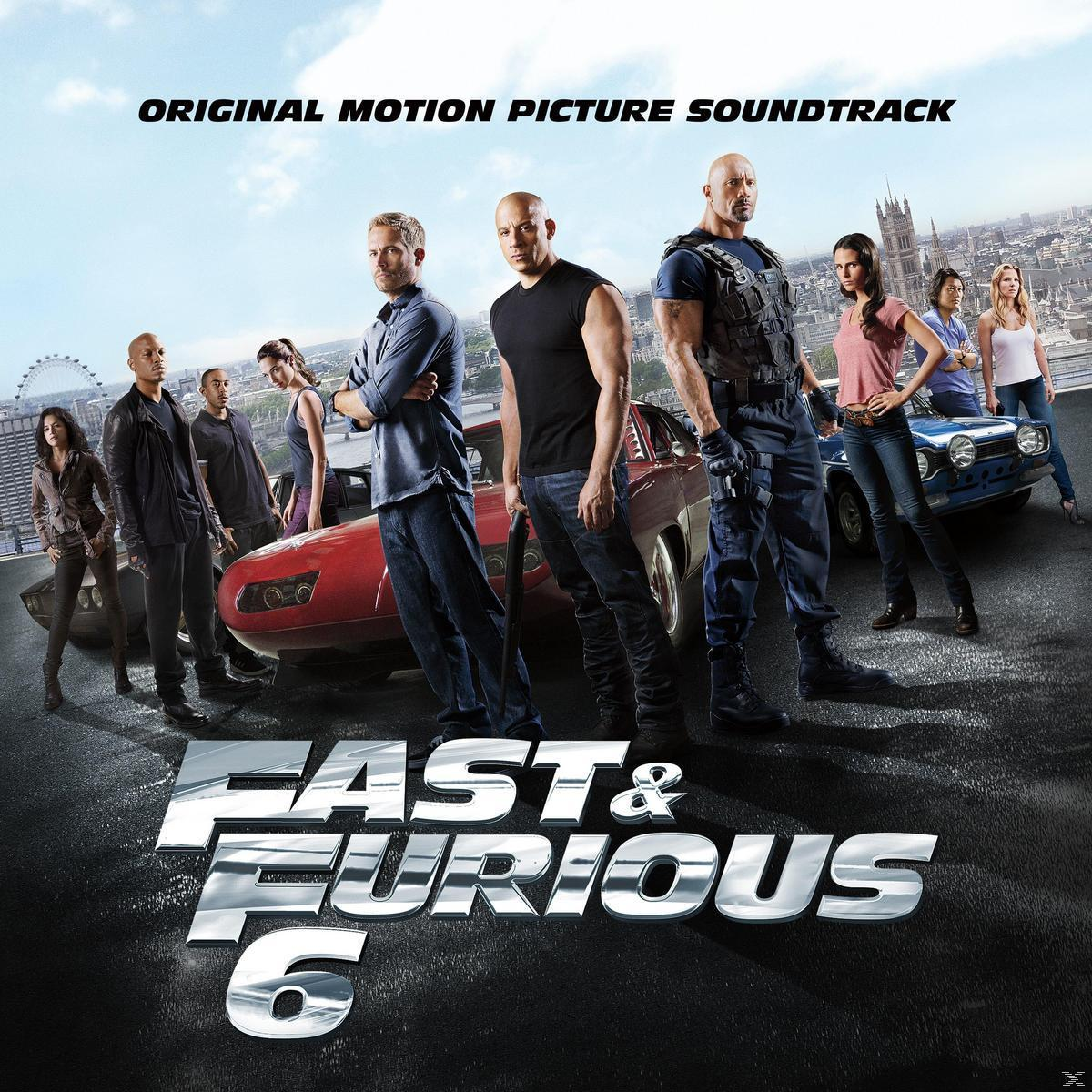 Couverture du film Fast & Furious 6. Plusieurs acteurs se tiennent devant une voiture rouge. Une ligne d'horizon est en arrière-plan.